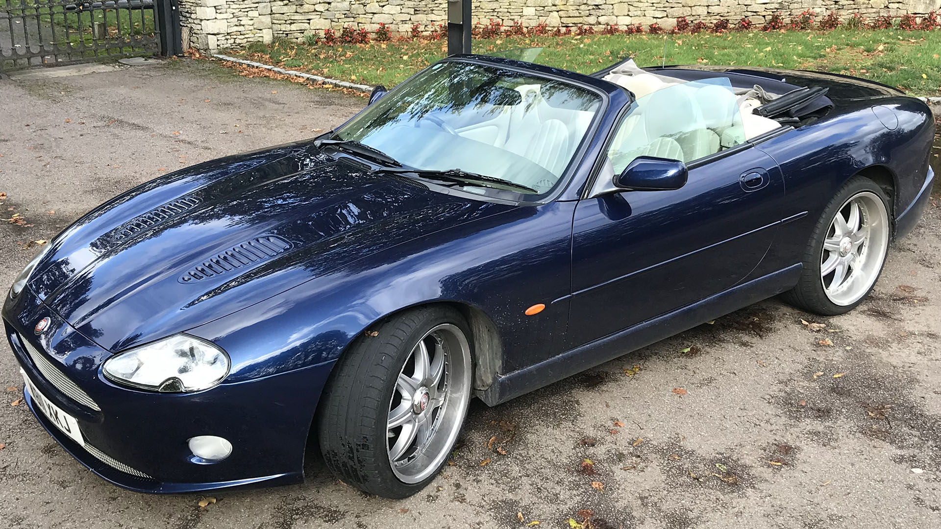 Aerial view of blue Jaguar XKR with roof down showing cream leather interior