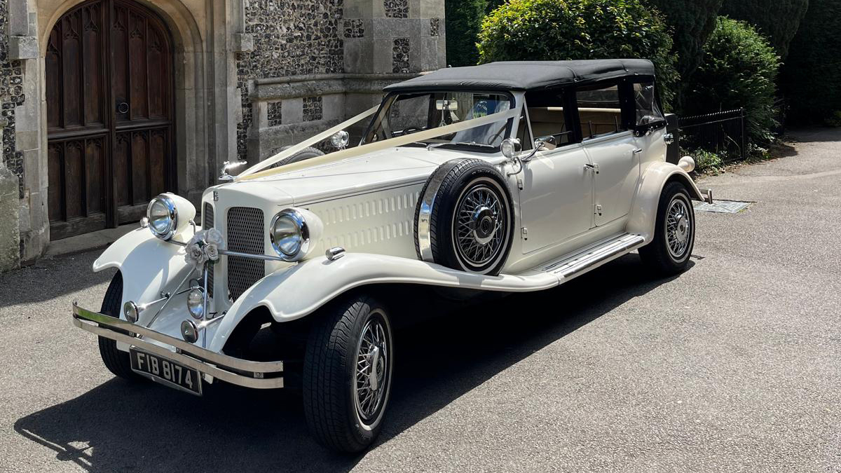 Vintage Beauford with white ribbons with black soft top roof closed