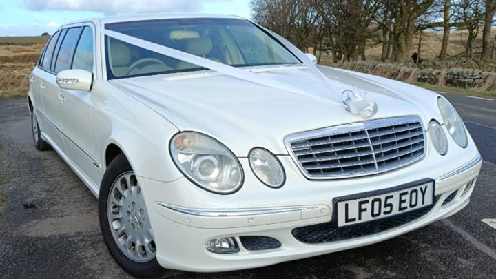 Front view of White Mercedes Limousine with white ribbons