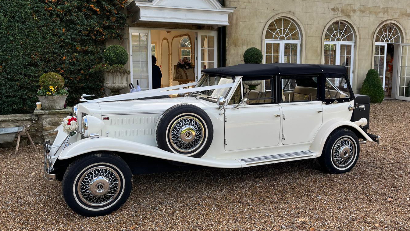 Right side view of Beauford Convertible with black soft top roof and spare wheel mounted on the side of the vehicle