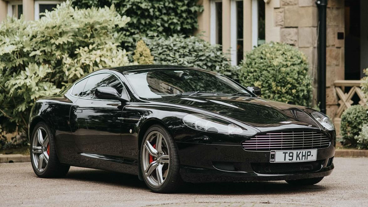 Front right view of black 2-door Aston Martin