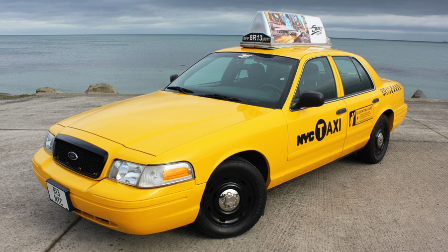 Ford Crown Victoria American Yellow Cab with black wheels andchrome centre cap