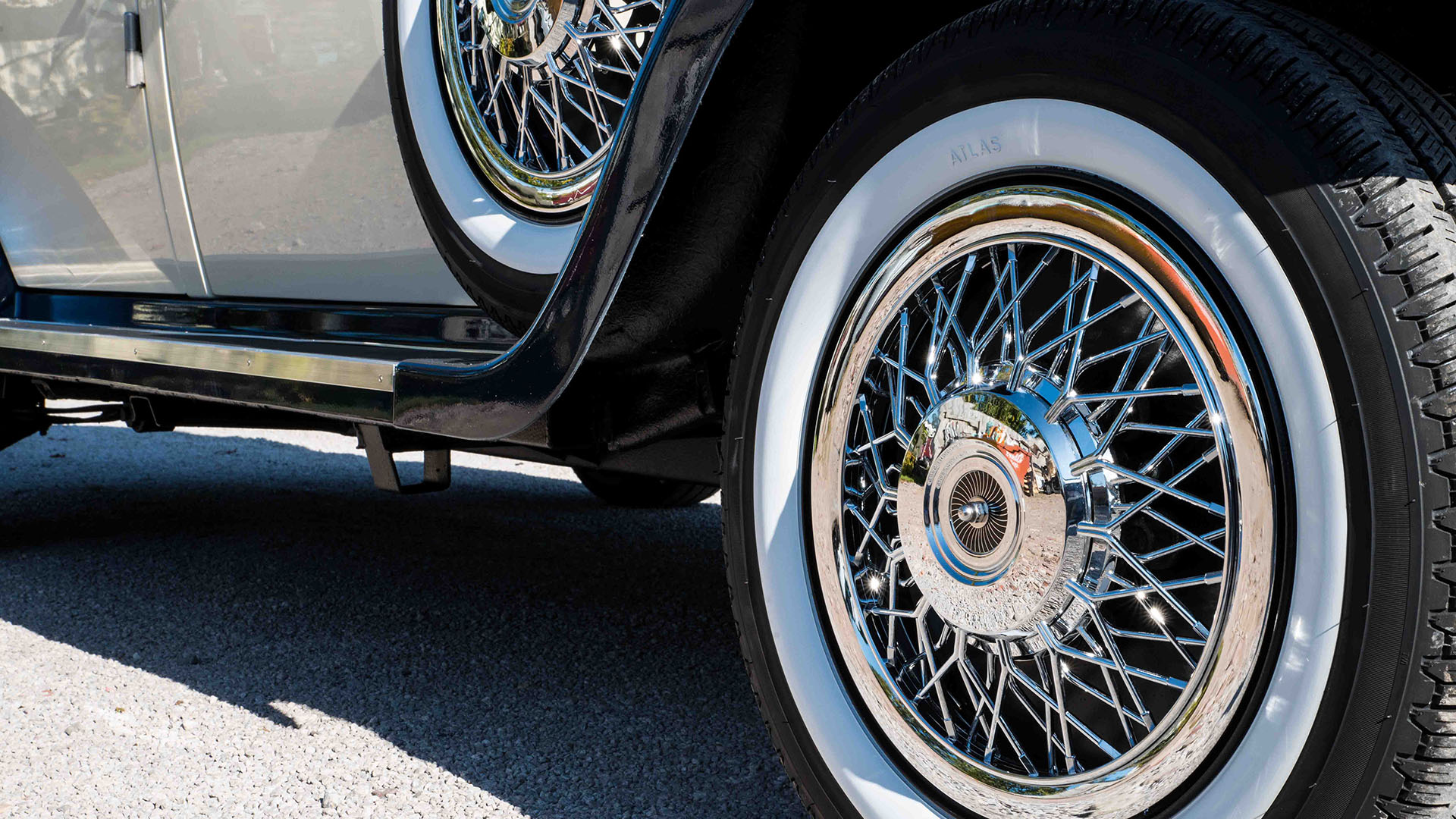 close-up view of chrome spoke wheels with white wall tires