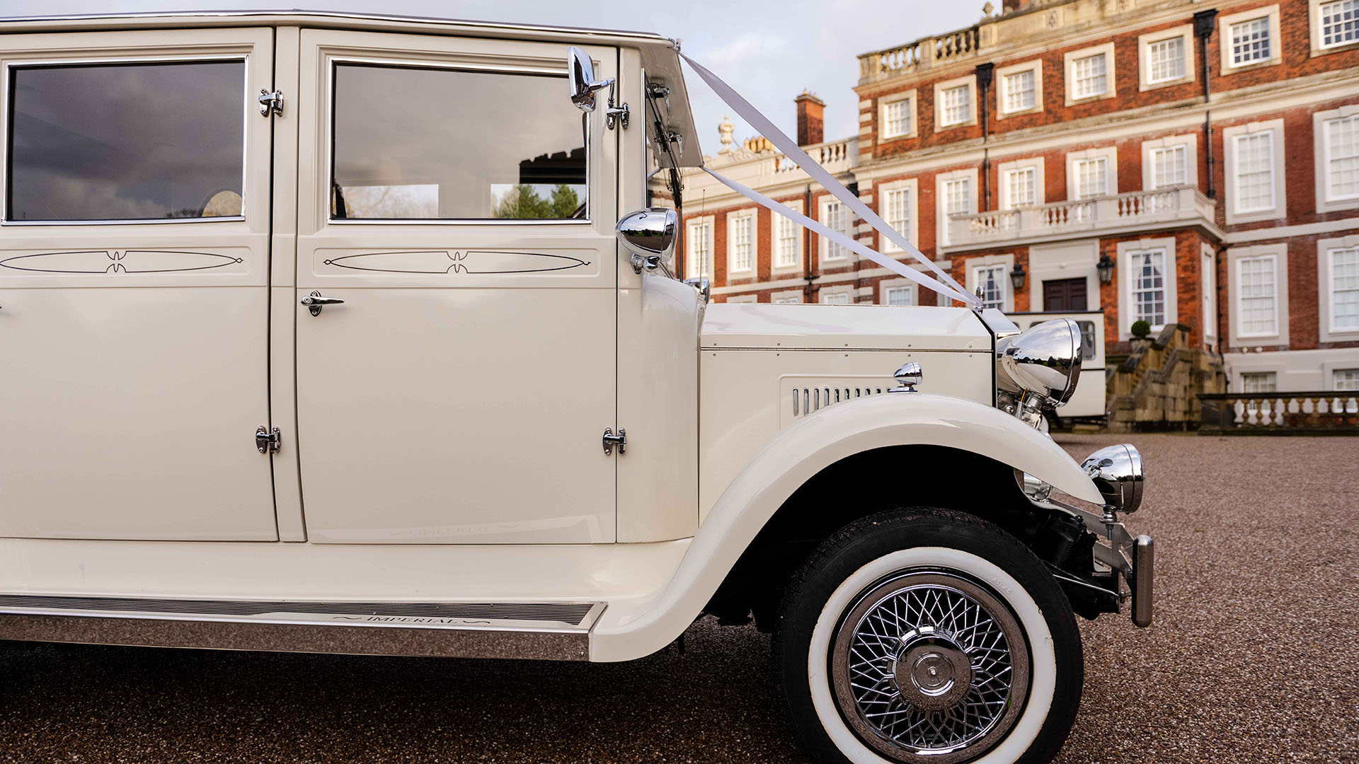 Clost-up view of the right front of Cream Imperial Wedding Car with white wall tires and chrome spoke wheels.