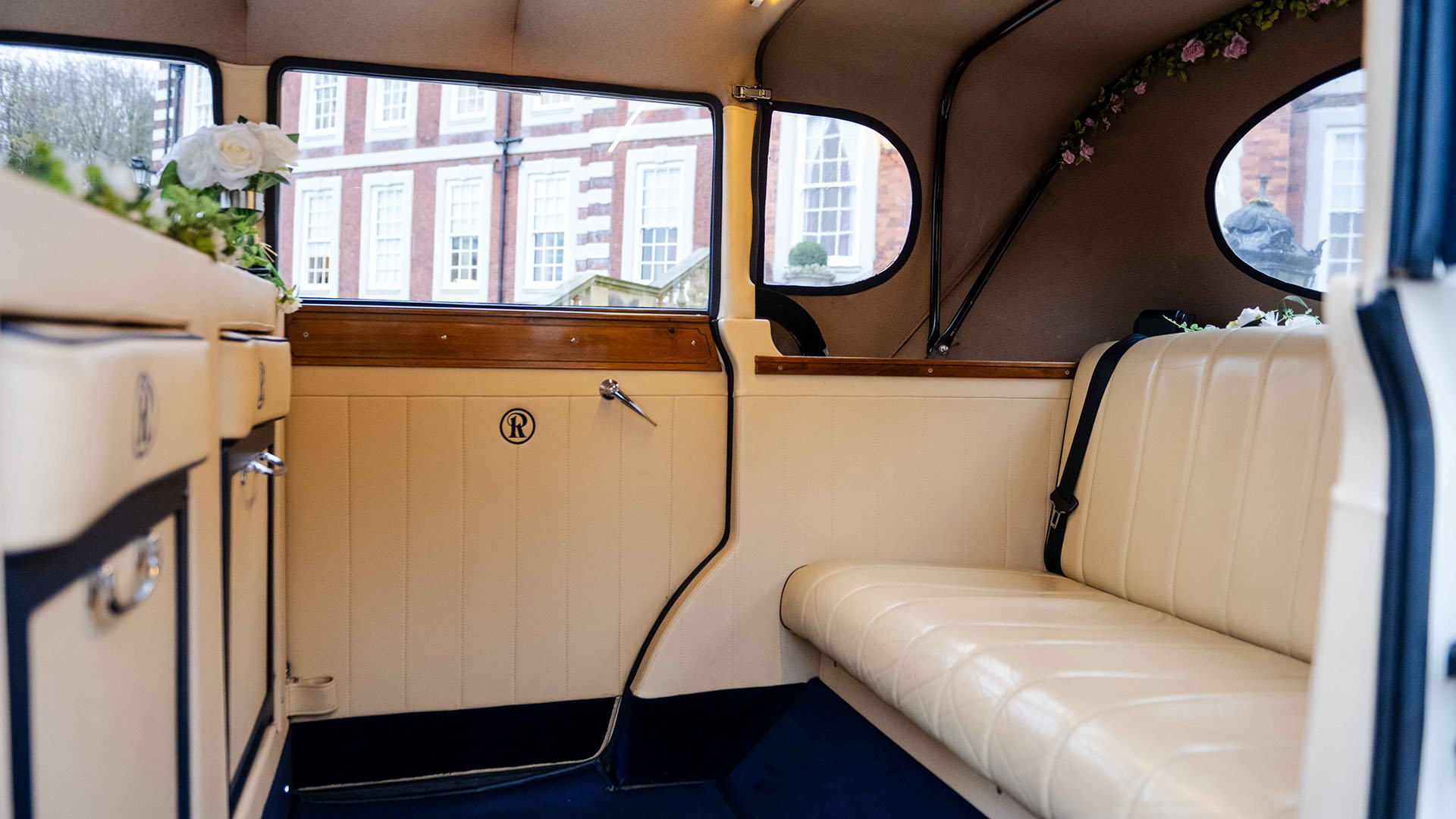 Rear interior cabin with cream leather seats and blue carpet