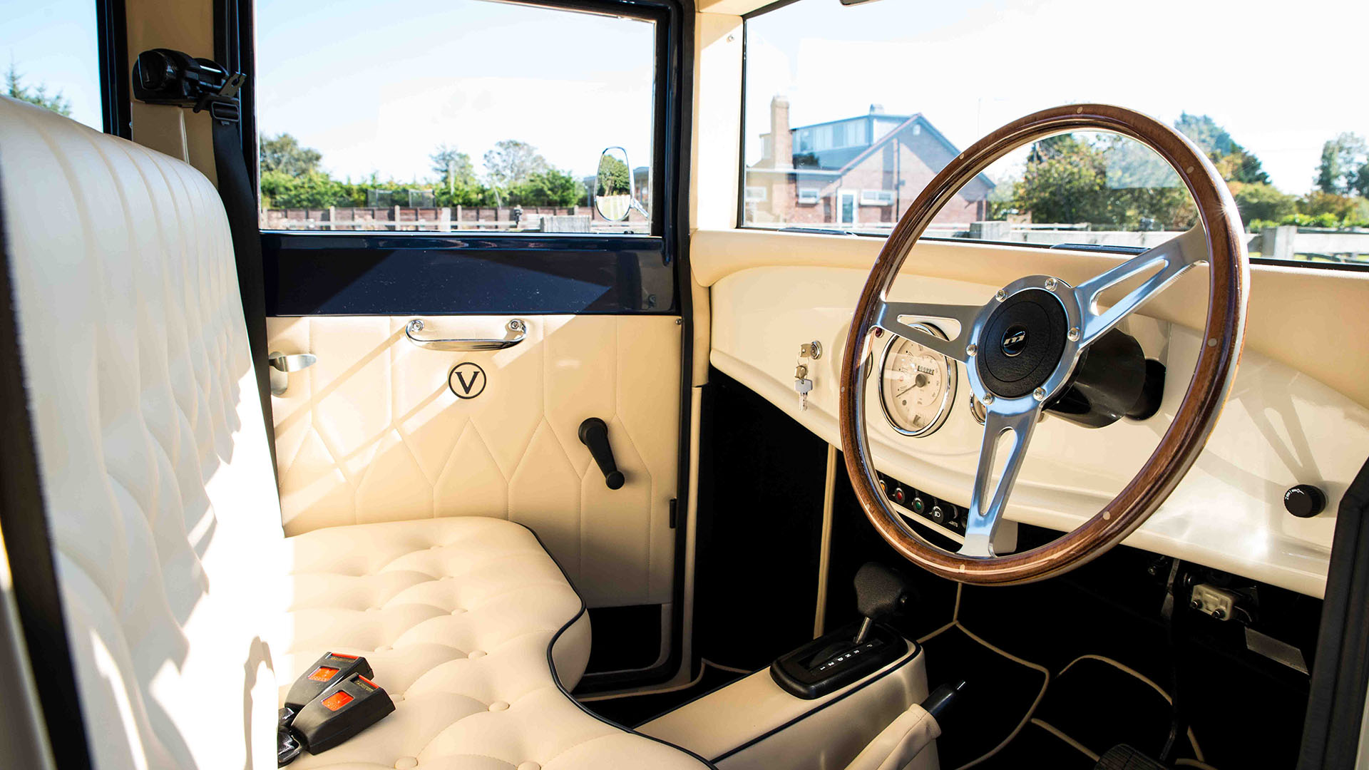 Front passenger cabin with cream leather and wooden steering wheel