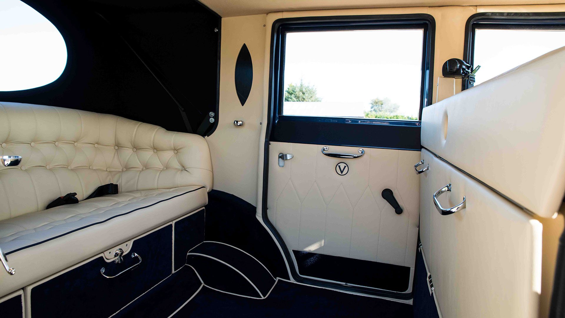 Rear interior cabin inside Imperial wedding car with Cream Leather seats with blue pipping and Navy blue carpet