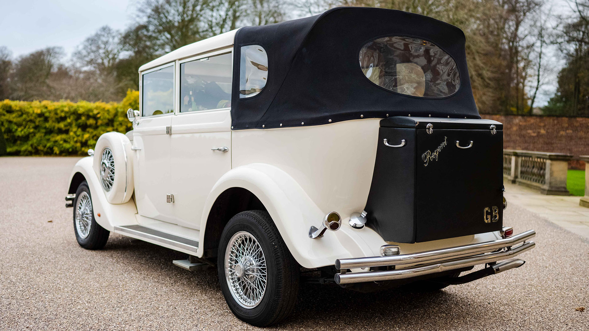 Rear view of Ivory Regent with black soft top roof and black picnic trunk at the rear