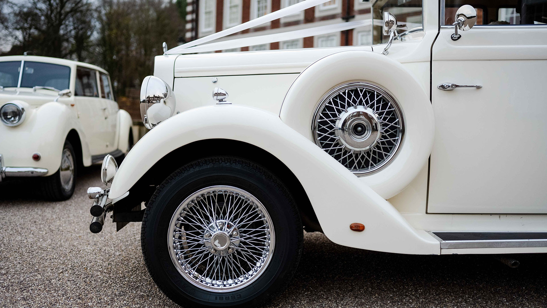 Close-up front view of chrome spoke wheel and spare wheel mounted on the side of the vehicle