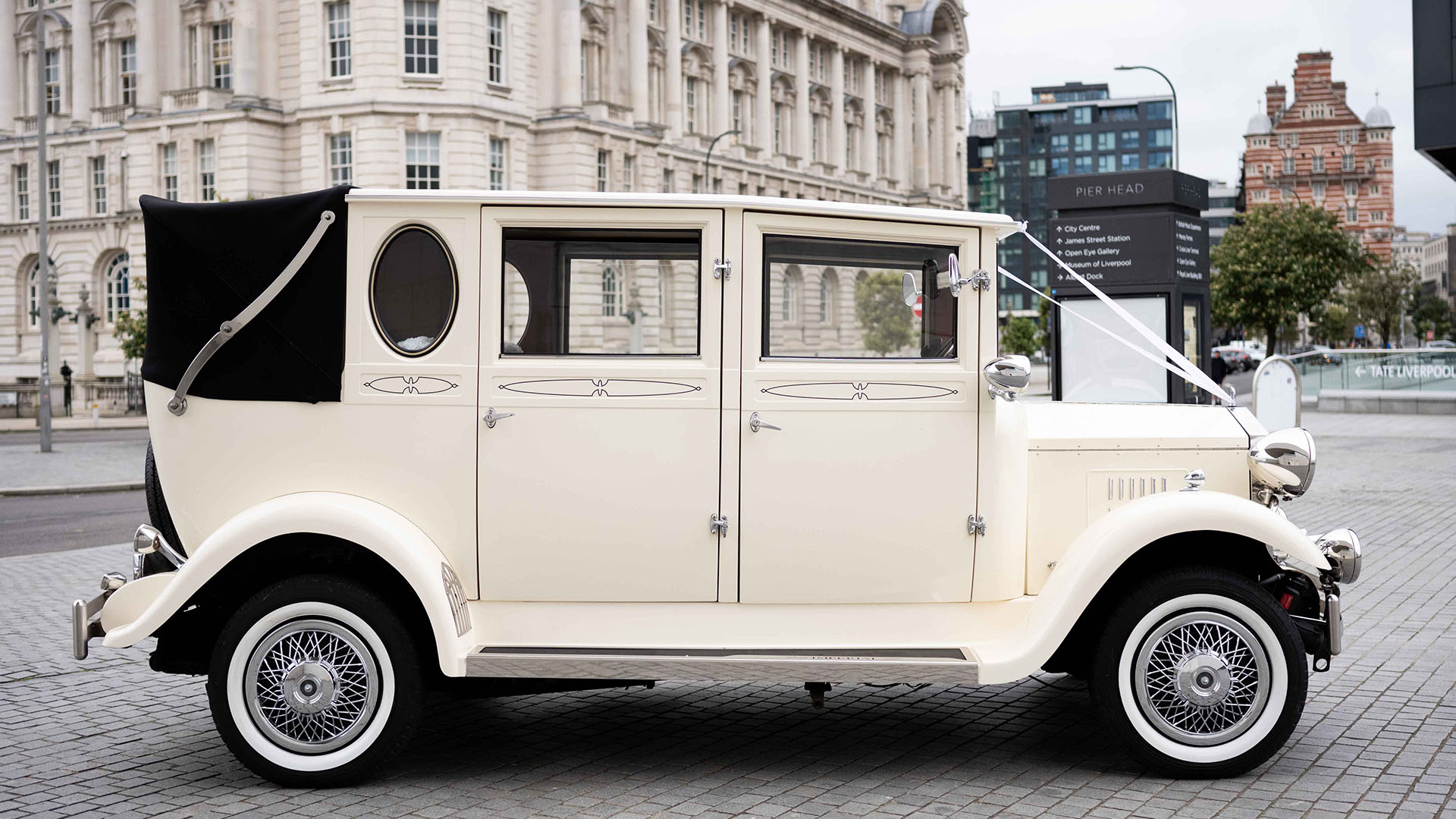 Right side view of Vintage Imperial in Old Englsih White with black soft top semi-convertible roof closed