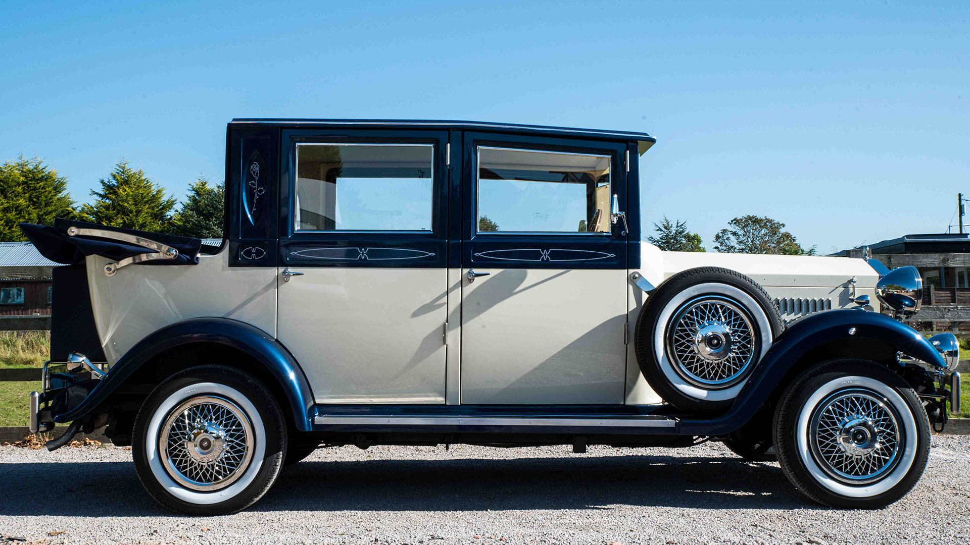 Right side view of a two-tonw Ivory and Metallic Blue Imperial with rear soft top roof open