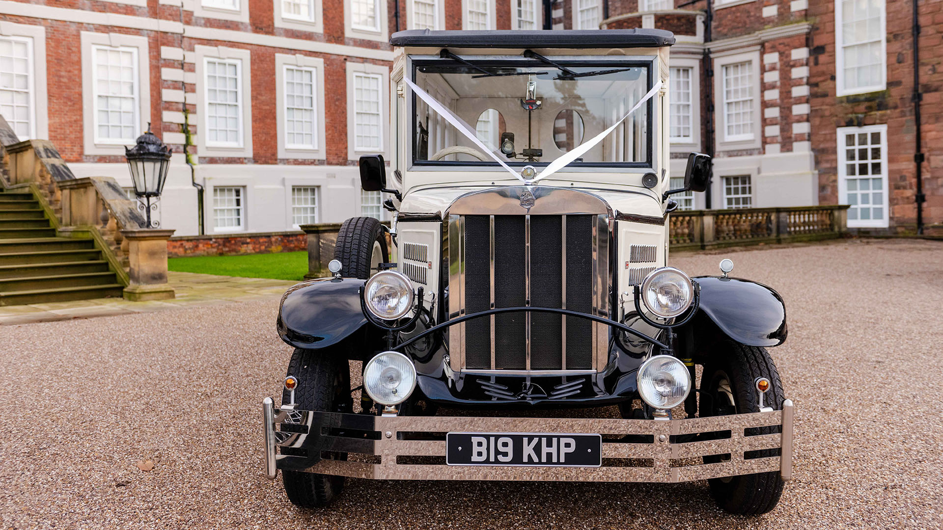 Front view of Asquith Wedding Bus with large chrome grill and white wedding ribbons across front bonnet.