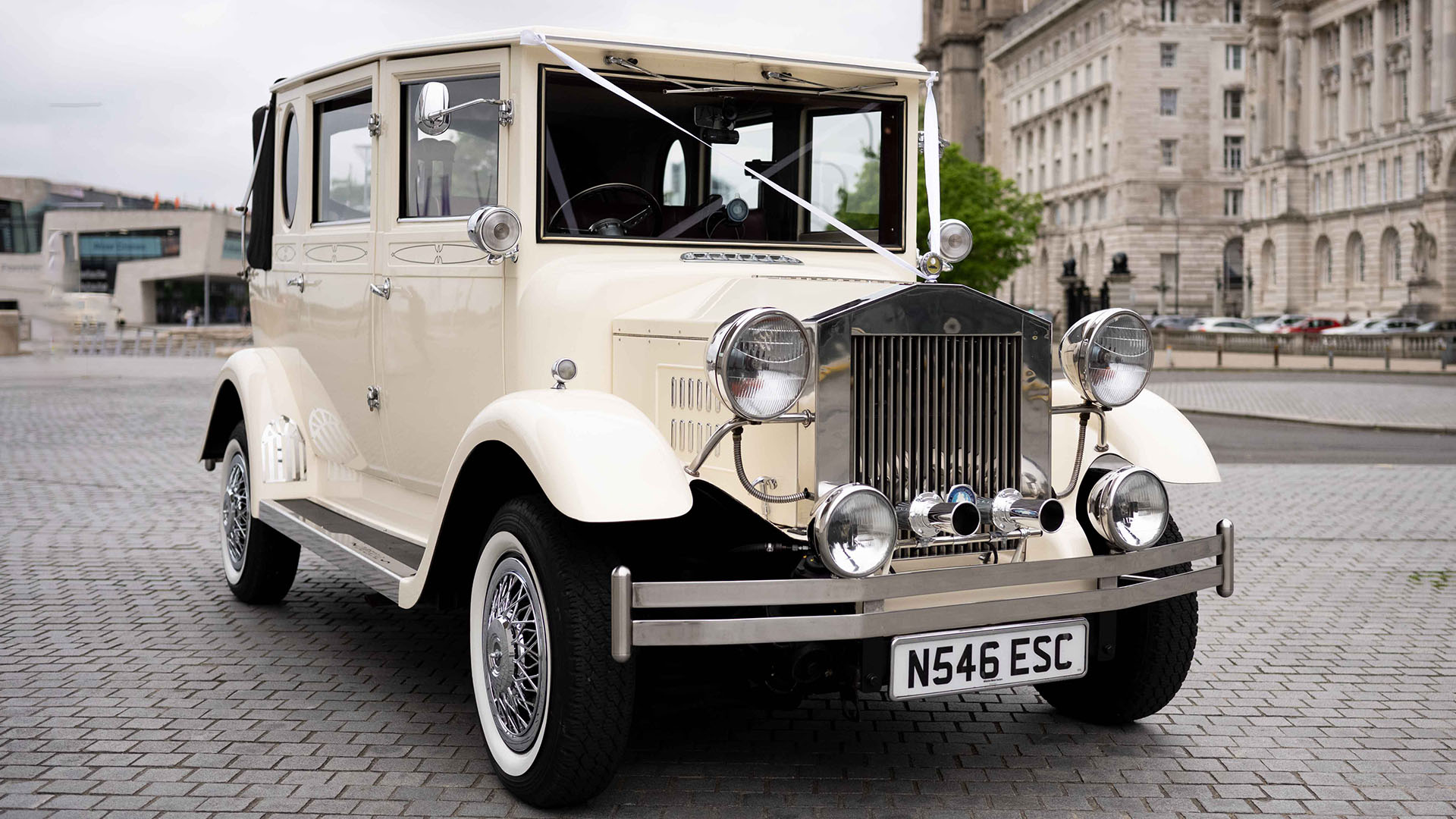 Imperial car in Old Englsih White with wedding ribbons across its front bonnet, chrome bumper and grill and white wall tires