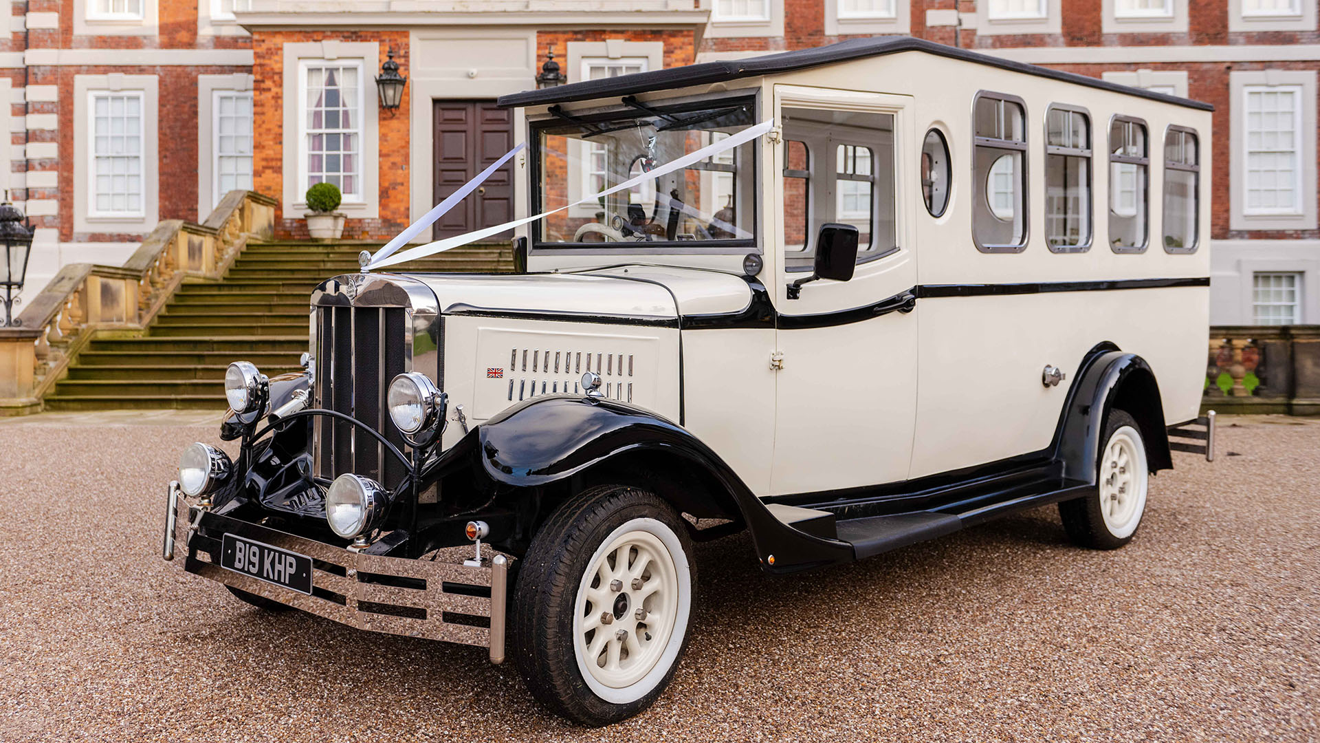 Asquith Bus in Old English White with black roof and  wheel arches decorated with white ribbons