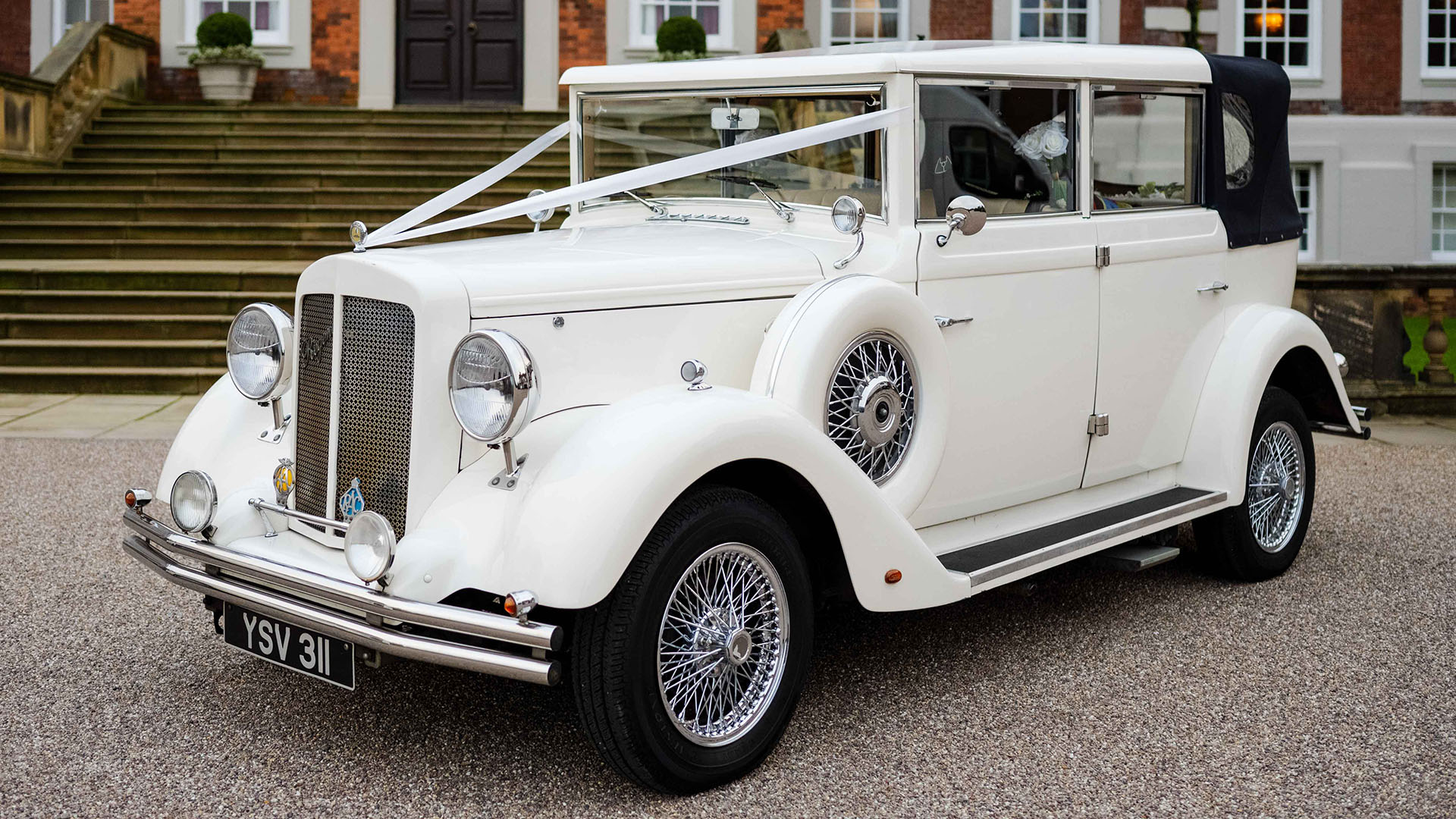 Ivory Vintage-Style Regent wedding car in Ivory with Black Soft-top retractable roof decorated with white wedding ribbons