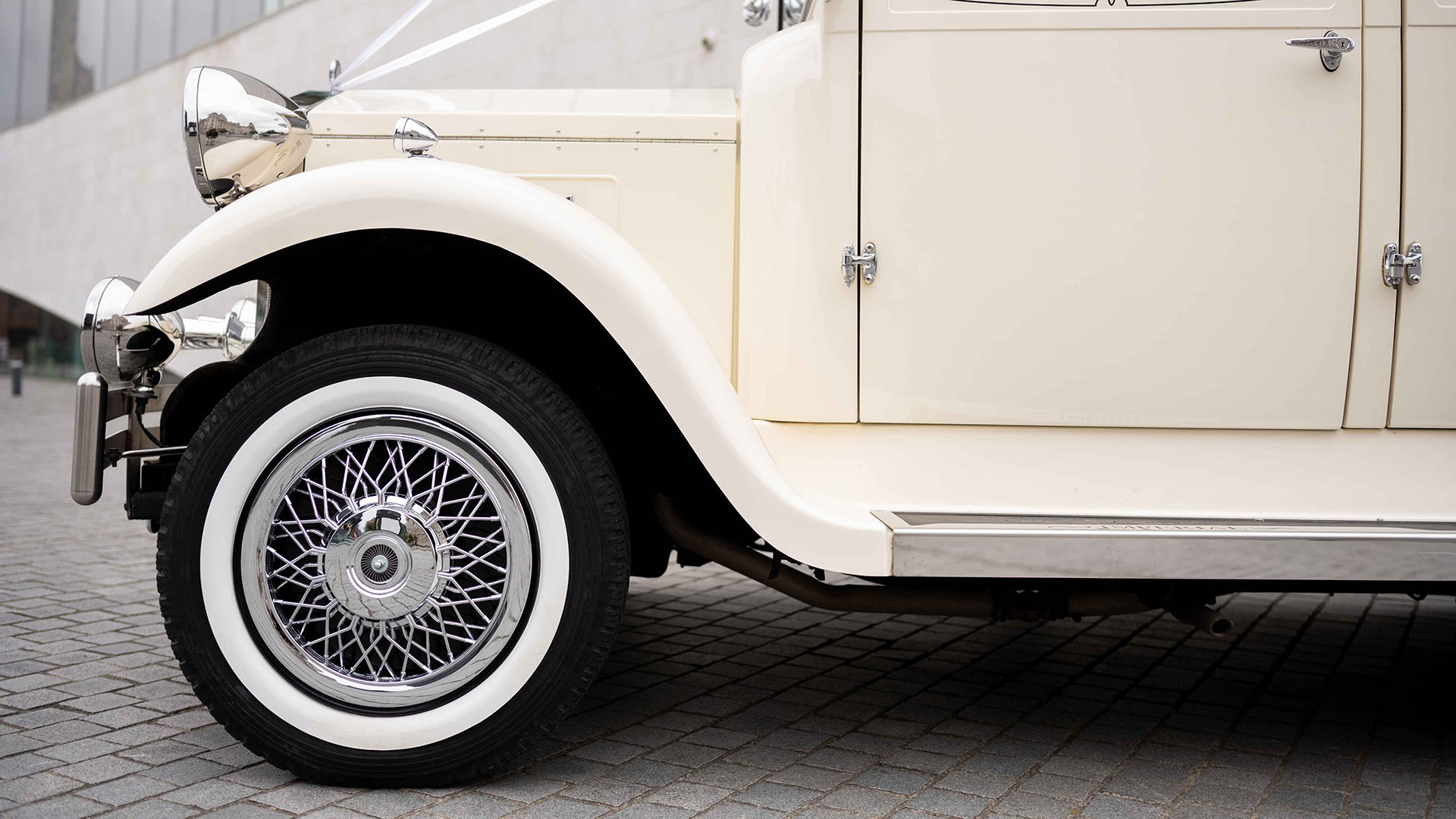 Close-up view of front wheels with chrome spokes wheels and white wall tires