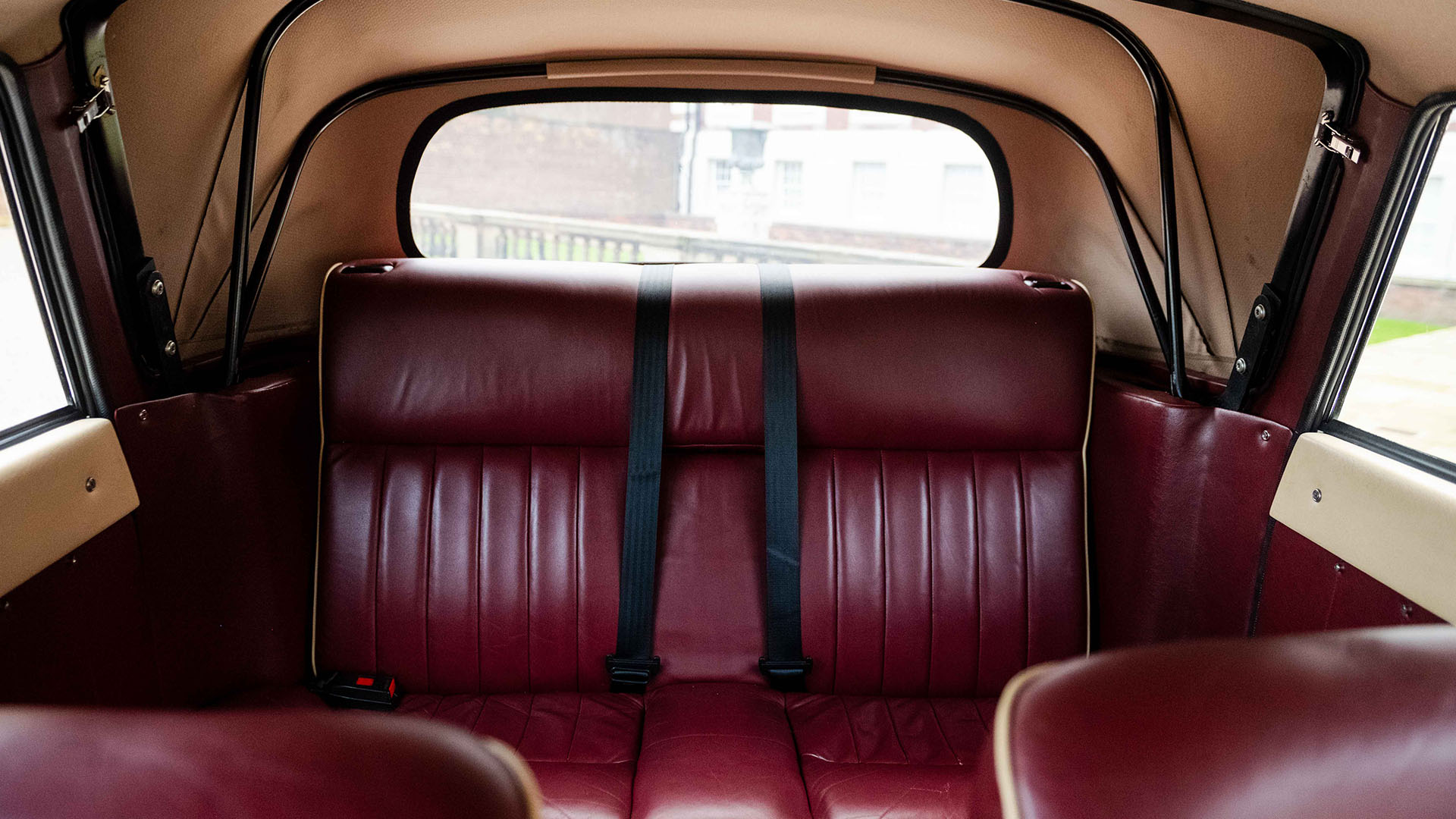 Rear interior burgundy seats inside a vintage Royale Windsor car