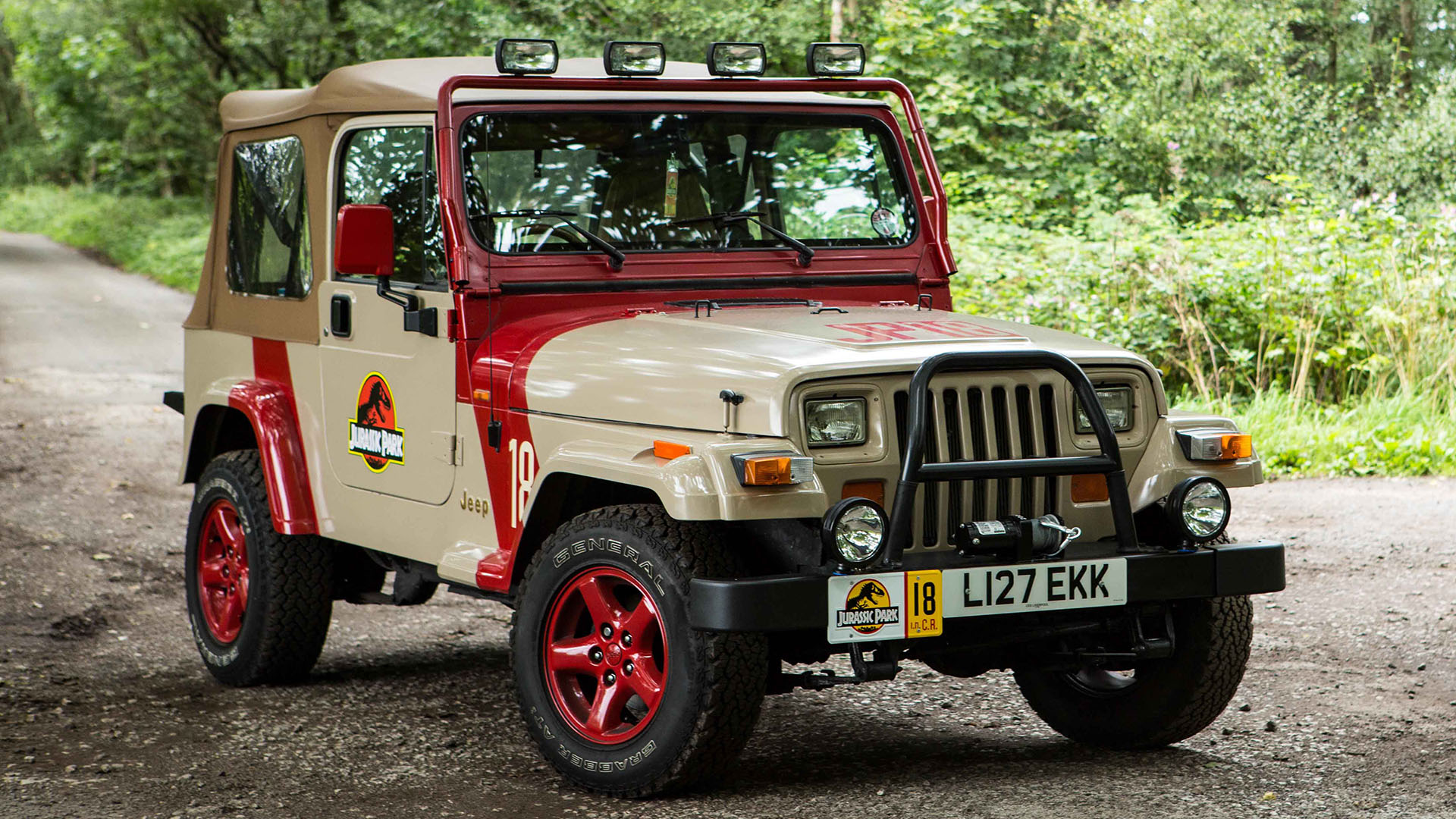 Classic 90s Jeep Wranger from the Jurassic Park movie in Sand Beige with red wheel and canvas roof