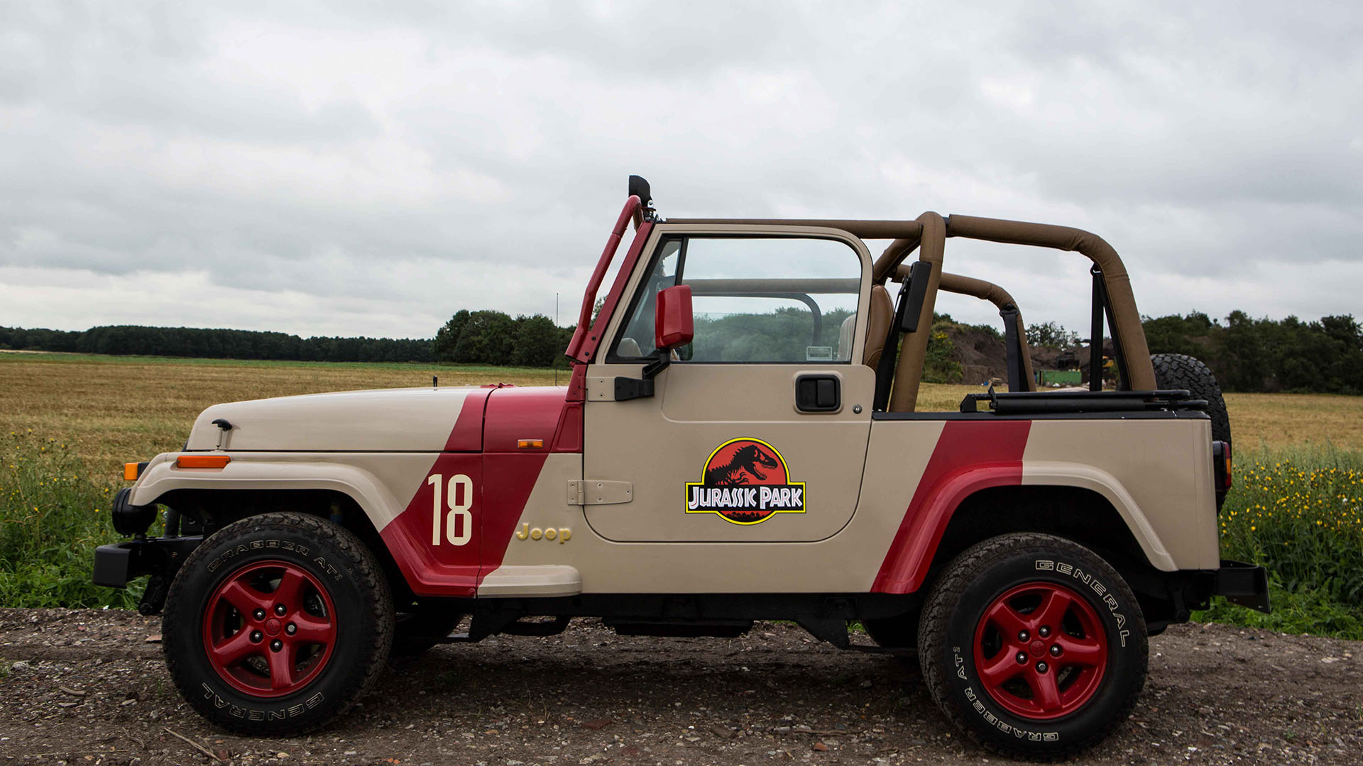 Left side view of Jeep with roof open and Jurassic Park logo in the middle of the door