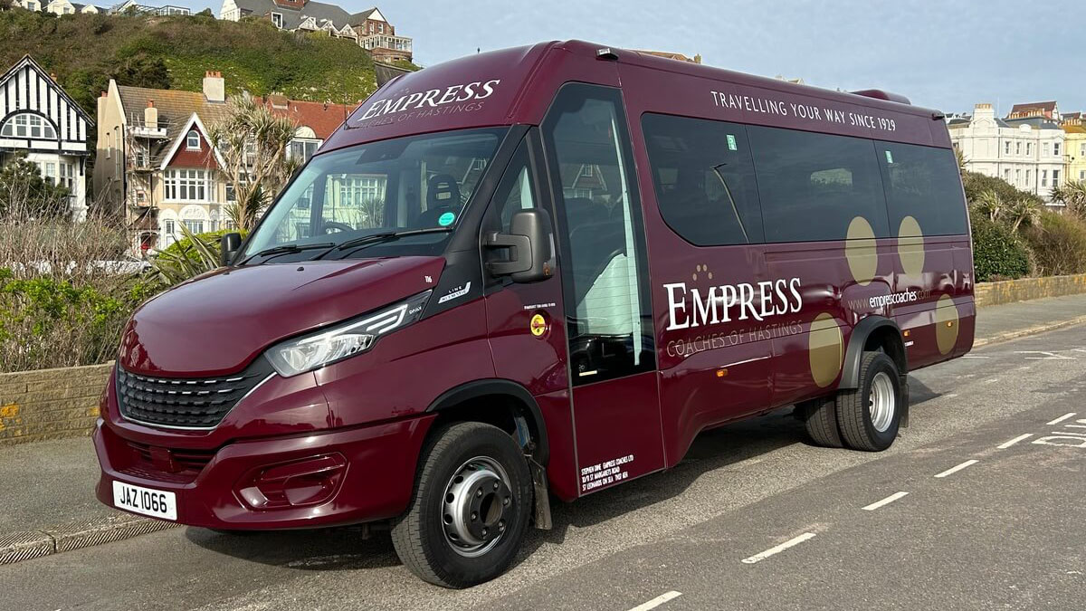 Left siode view of Burgundy Modern Coach with privacy rear windows