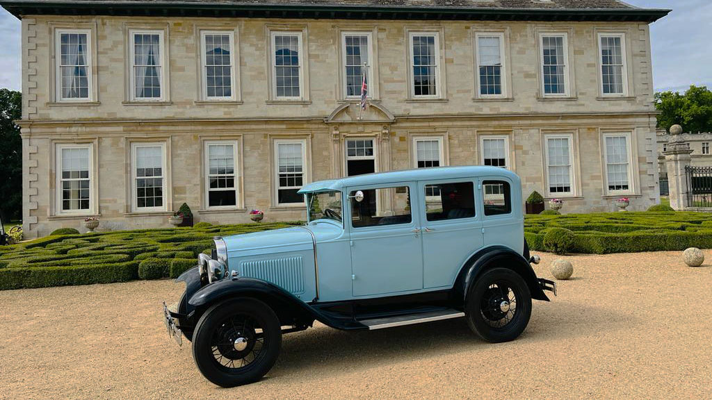 Light blue Ford Model A parked in frotn of a wedding venue in Leicester