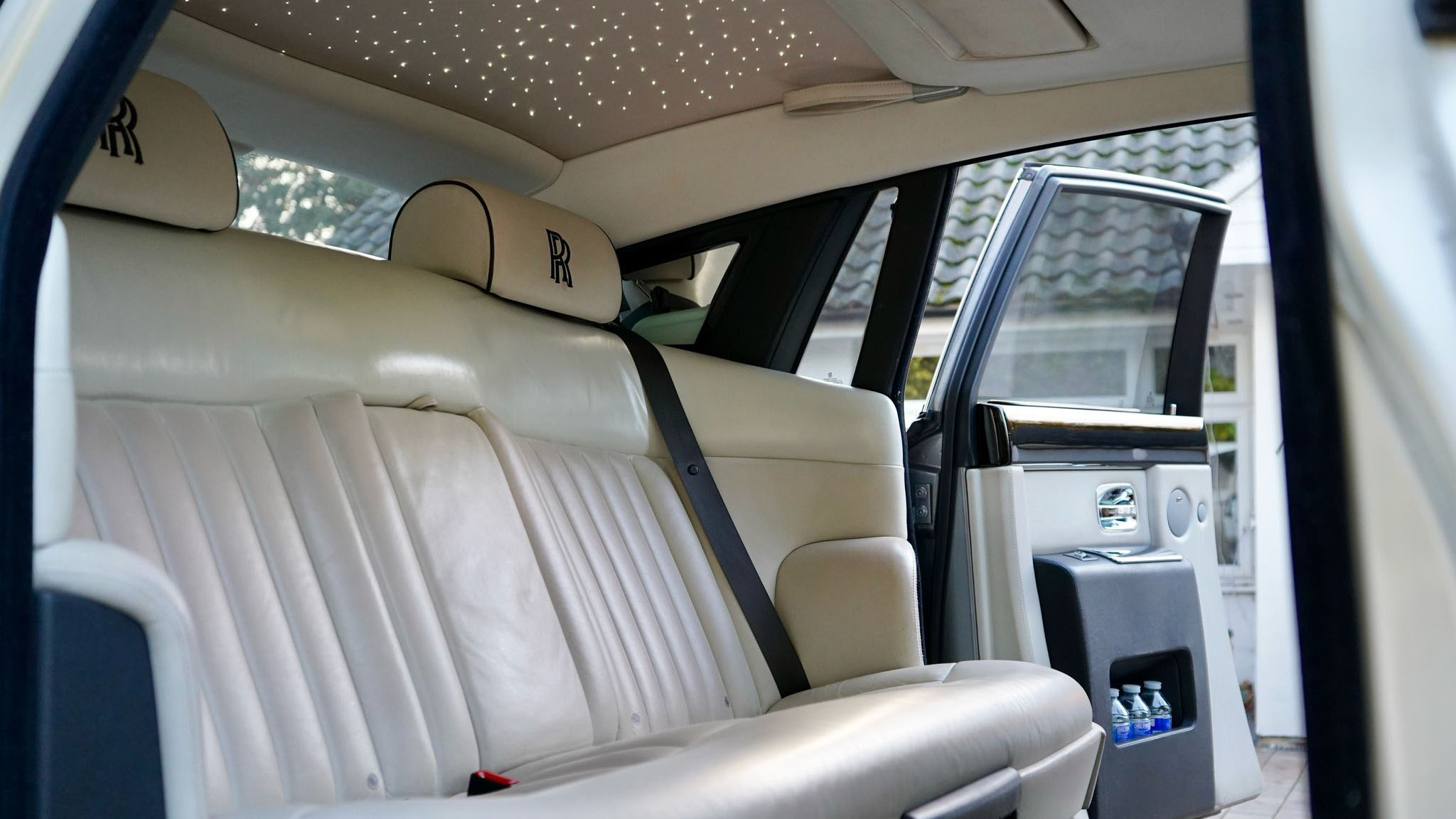 Black Rolls-Royce Phantom rear cream interior seat with skylight ceiling