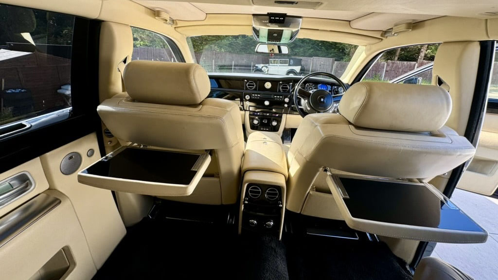 Black Rolls-Royce Phantom interior with cream interior seats and picnic table