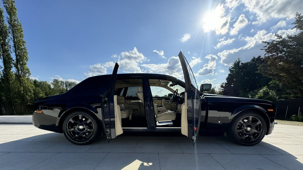 Right side view of Black Rolls-Royce Phantom with black alloyr wheels and both coach doors open