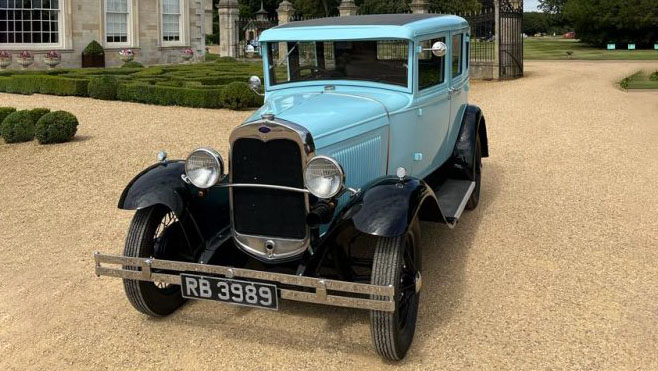 Left side view of a vintage Ford Model A in Powder blue with black wheel arches