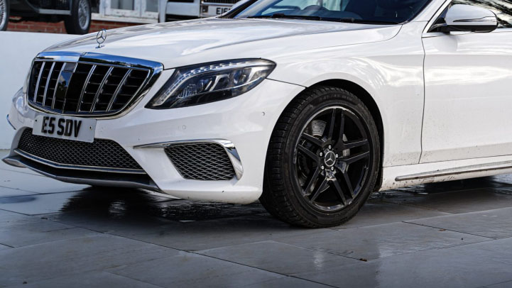 close-up view of White Mercedes Front grill and black alloy wheels