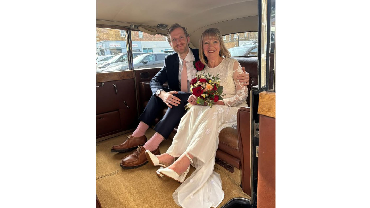 Bride and Groom seating in the rear of a classic Limousine with Brown leather interior and tan carpet