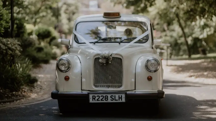 Front view of classic Ivory taxi cab dressed with ribbons and floral bouquet on front grill