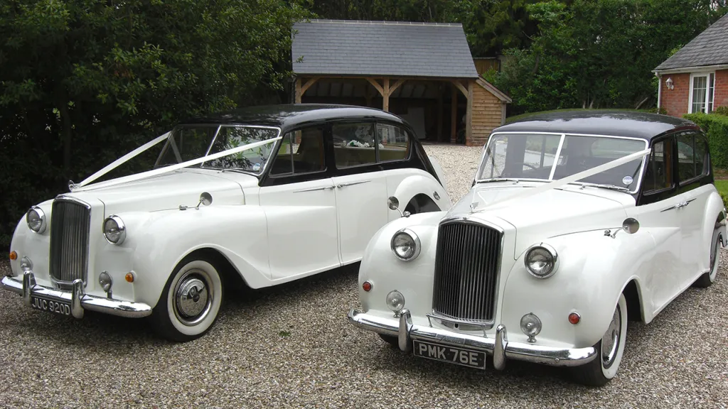 Two Identical Austin Princess Limousine standing in front of a wedding venue