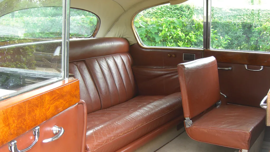 Brown Leather interior of an Austin Princess with casual seat up in front of the rear bench seat.