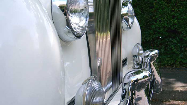 Close-up photo of Rolls-Royce Chrome Grill and single headlight
