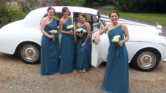 Bride and her bridesmaids standing in front of  Rolls-Royce Silver Cloud before entering the Ceremony