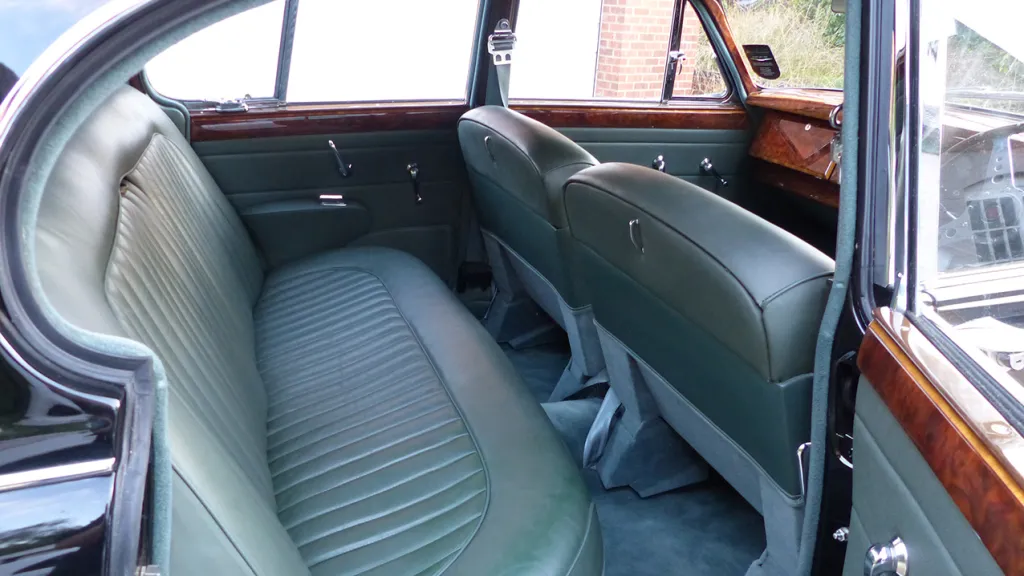 Rear inside view of Jaguar Pale Green LEather interior, with wooden door panel on top