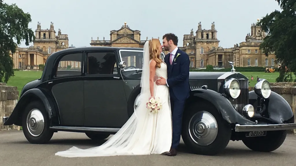 Rolls-Royce Phantom II Continental LWB with bride and groom kissing in front of the vehicle