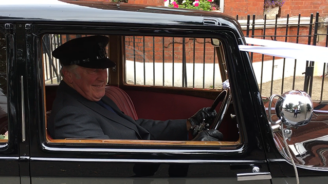 Fully uniformed chauffeur seating inside the vintage Rolls-Royce Phantom II Continental LWB