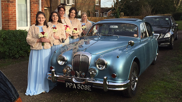 Classic Daimler with five Bridesmaids stnading by the vehicle wearing matching light blue dresses