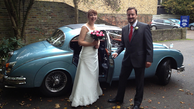 Groom holding the door of the Daimler for his Bride