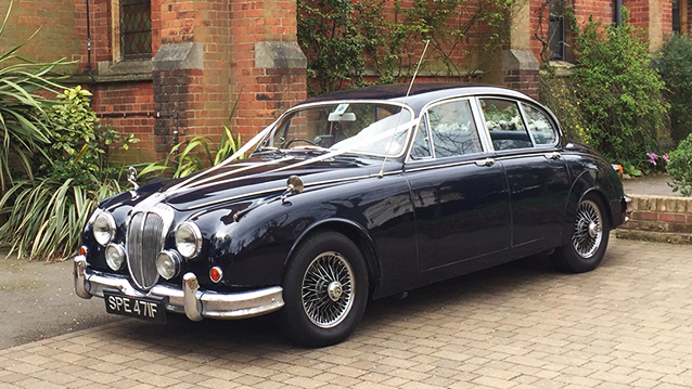 Front left side view of a classic Daimler 250 V8 with white ribbons