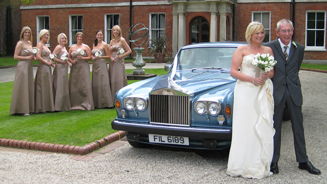 Six Bridesmaids with matching Ivory dressed stands in the background and Bride and Groom at the front of the  Rolls-Royce Silver Shadow II in Blue and Silver