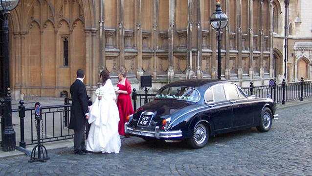 rear view of Dark Blue Daimler 250 with Bride and Groom entering the Cathedral