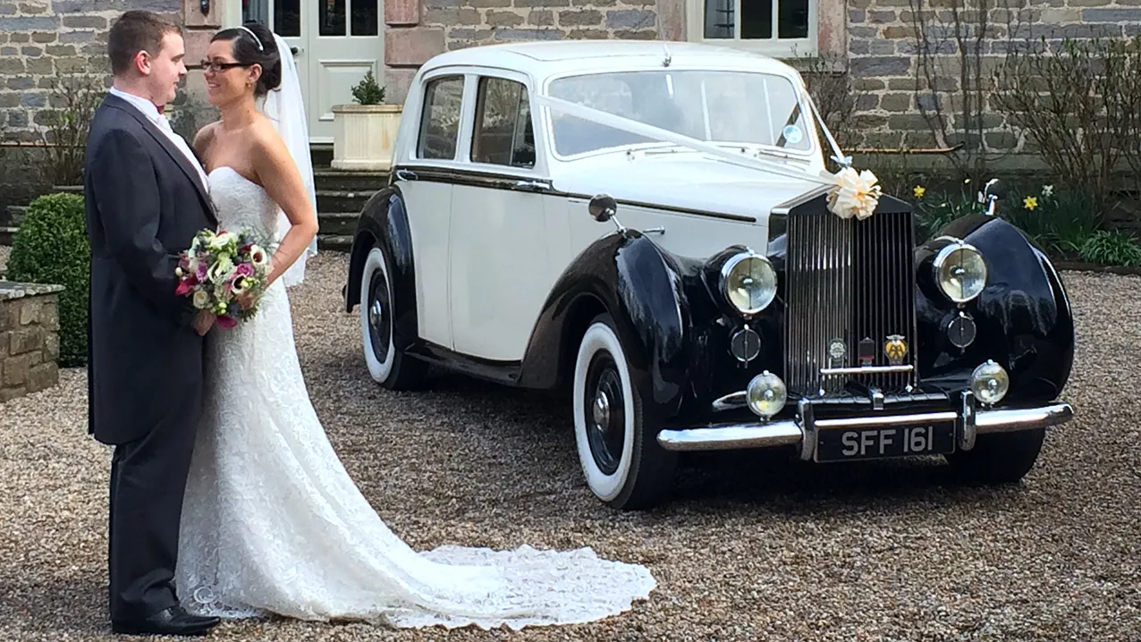 Bride and Groom standing by the classic Wedding Car they've hired for their Yorkshire Wedding