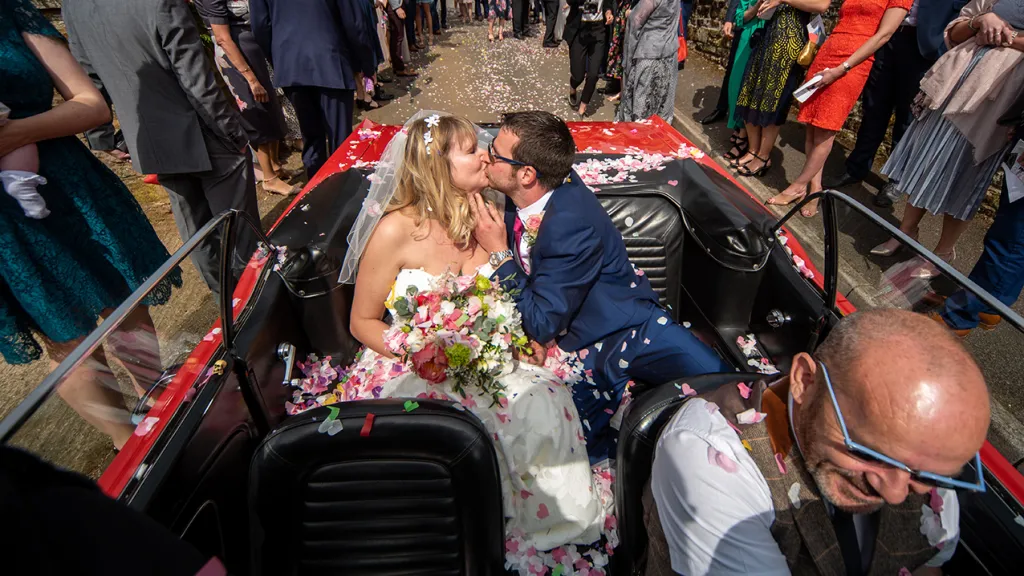 Bride and Groom kissing inside the Ford Mustang