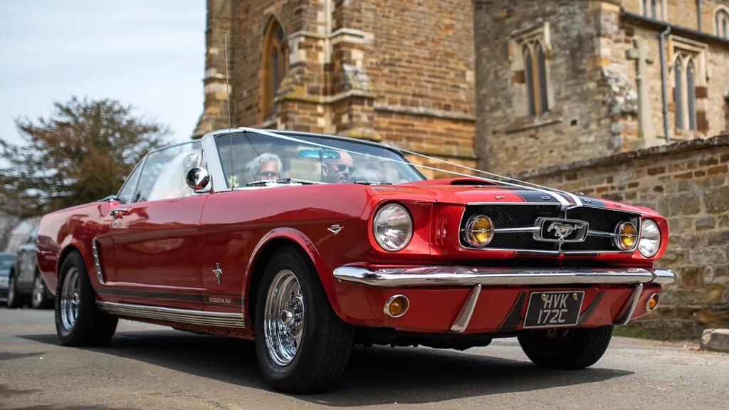 Ford Mustang Convertible with white ribbons in front of a church