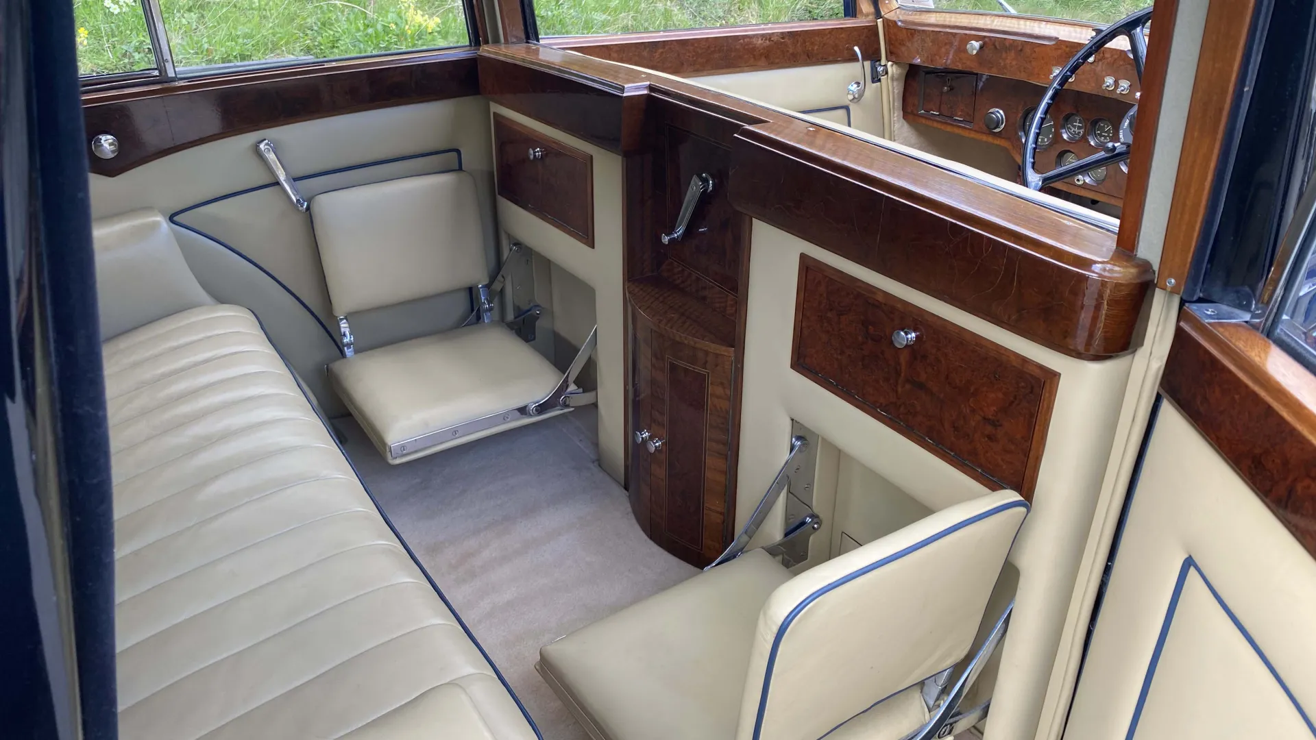 inside rear cabine of Rolls-Royce Sedanca de Ville showing cream leather leather interior and wood inside the vehicle