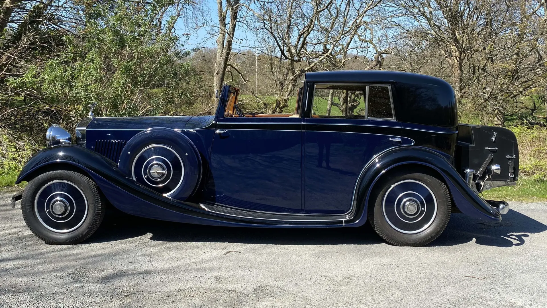 Left Side view of vintage Rolls-Royce Sedanca de Ville in Blue showing the black picinic trunk at the rear