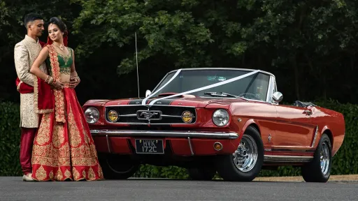 Asian Couple in front of the Classic Car They've hired